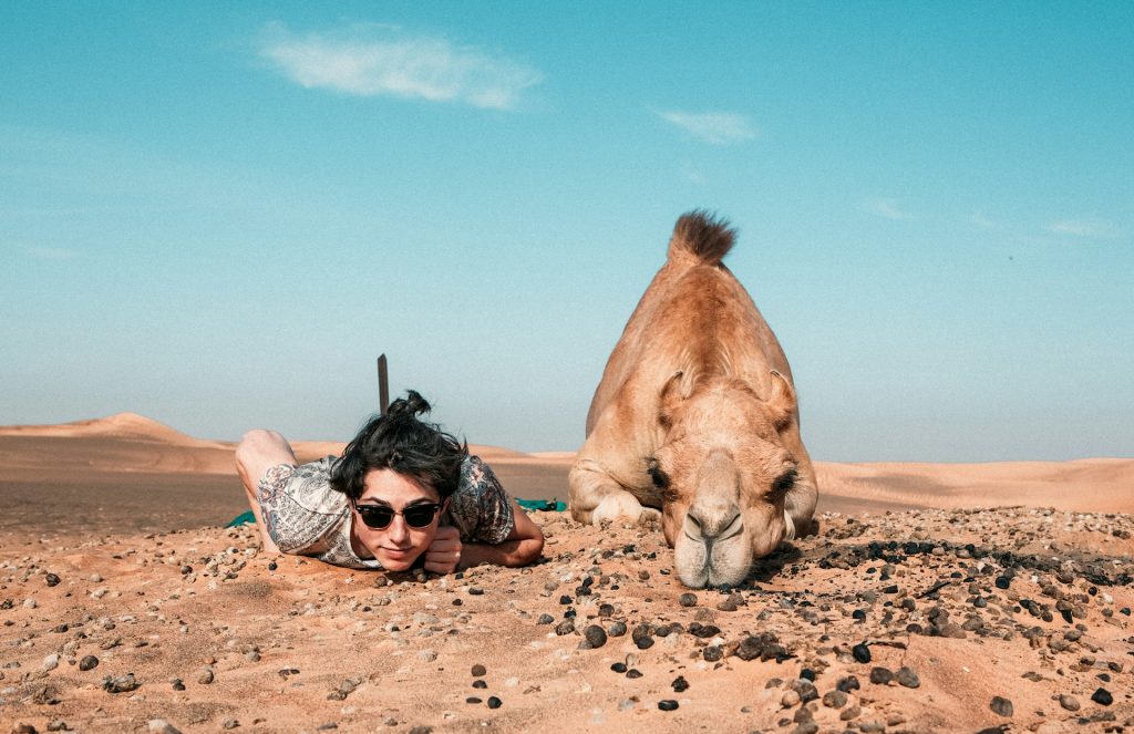 man-and-camel-lying-on-ground