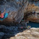 people-rock-climbing-on-sea-shore