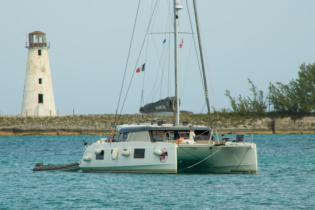 a-sailboat-in-the-water-with-a-lighthouse-in-the-background